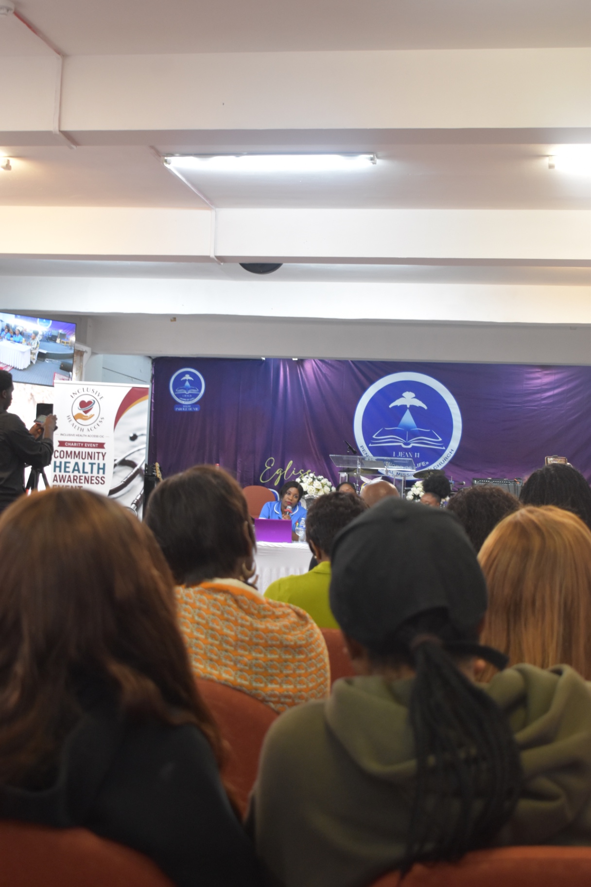 Speaker addressing a full room at the Community Health Awareness Event
